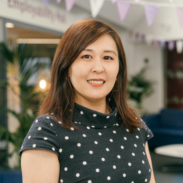 Profile picture of Image of Dr Jiao Ji stood in front of blue sofas in Sheffield  Management School