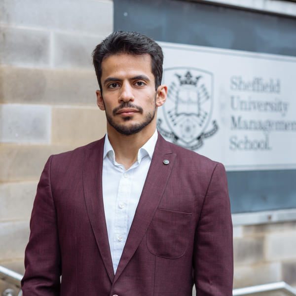 Profile picture of Abdullah AlGhizzi wearing a white shirt and dark red blazer.