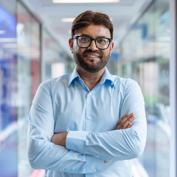 Profile picture of Sajid Bashir wearing a light blue short with his arms folded.