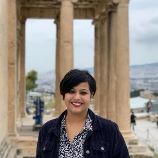 Profile picture of Anwesha Roy smiling in front of the Erechtheion