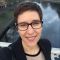 PhD student Helen looks at camera against river backdrop