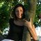 Nicoletta smiling and sitting in the bough of a tree
