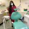 Dentistry female student with mask stands behind dentist chair