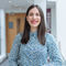 Atefeh Afsari standing in the Management School wearing a blue floral shirt.