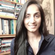 Shabana Roscoe smiling in front of a book case
