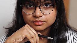 A profile photograph of masters student Umanga Perera. She is holding a pen. 