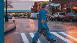 A book cover showing a clown crossing a road
