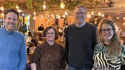 Four people stood smiling for the camera 
