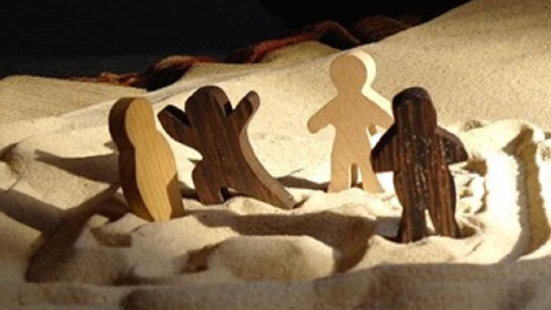 An image of figures in sand