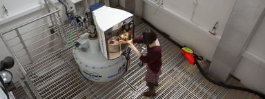 A researcher loads a sample into the 800 MHz spectrometer