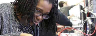 Female student using a circuit board in the Electronics lab