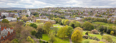 Aerial view of Sheffield. Green spaces interspersed with old and new architecture.