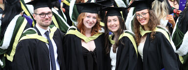 Group of happy graduating students standing outside