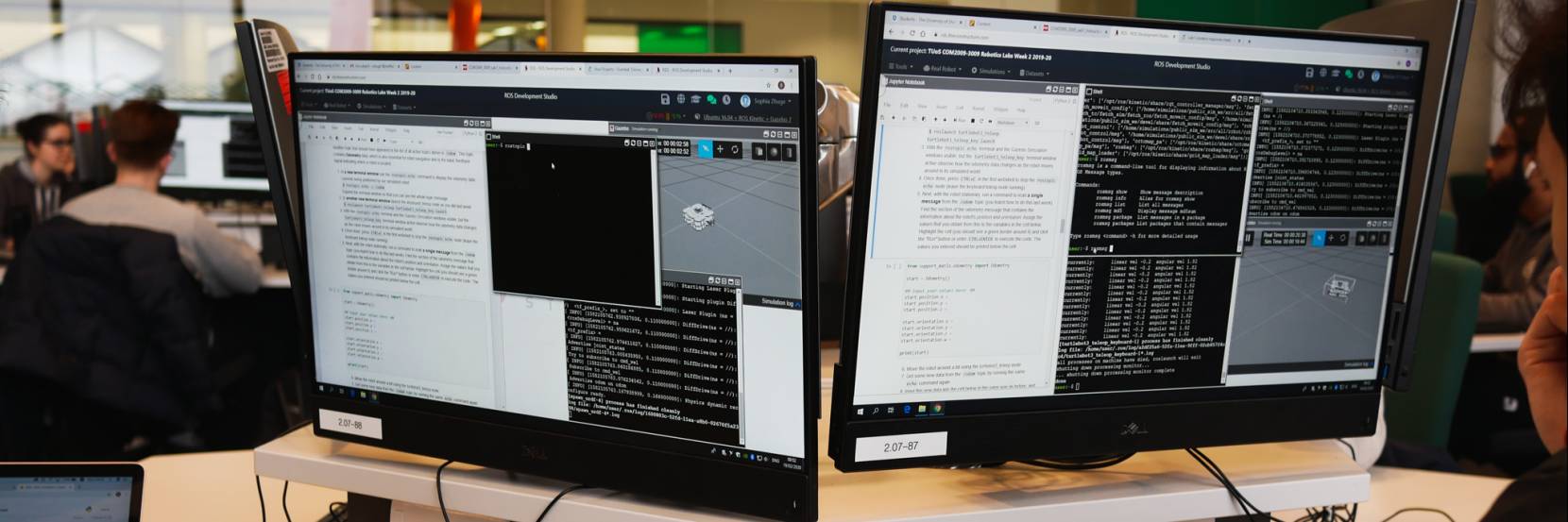 Two computer screens showing code and a virtual environment for programming robots