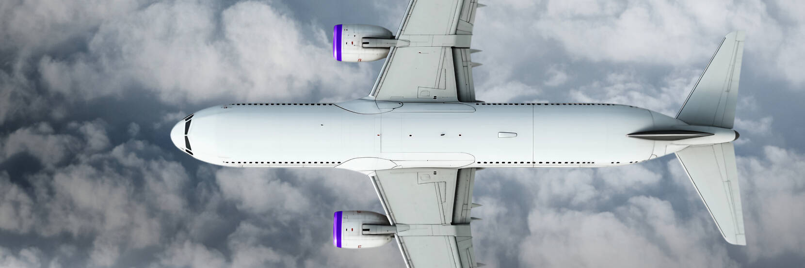Image shows a top down view of an aeroplane in a cloudy sky. 