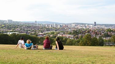 Students sat in park overlooking the Sheffield skyline