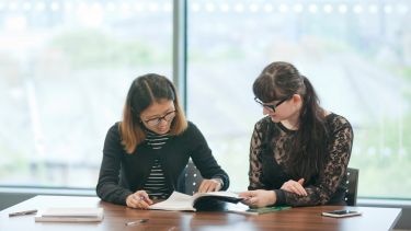 Two Education postgraduates at table