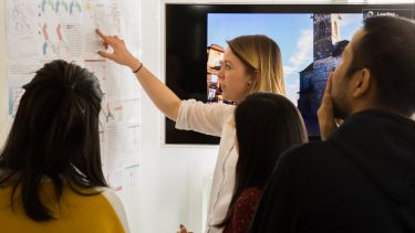 Sustainable architecture studies students discuss project with board