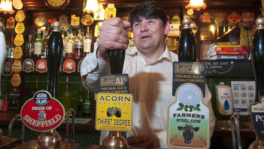 A member of staff working behind the bar of a pub 