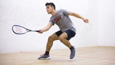 A student playing squash in the university gym 