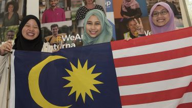 Malaysian students hold a flag. 