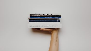 hand holding pile of books