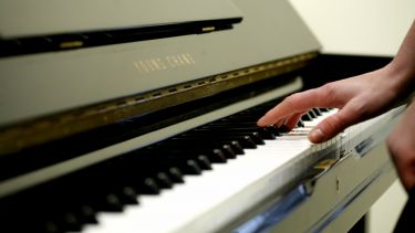 Close up of someone playing a piano