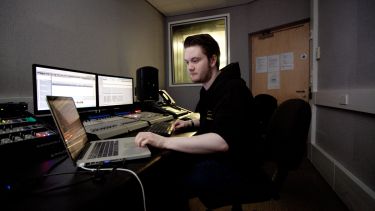 A student producing music at a computer