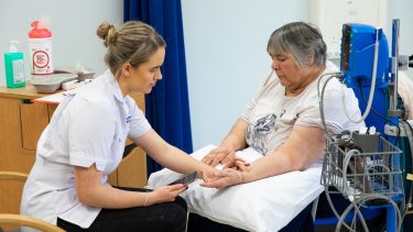 A trainee nurse taking a patient's pulse.