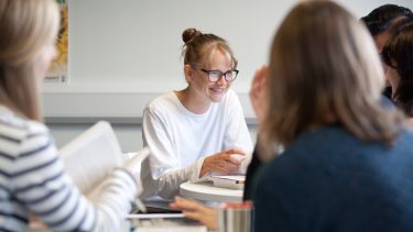 Postgraduate students studying together in the common room