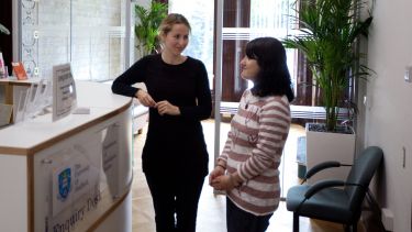 Two research students stood at the enquiry desk in the Department of Sociological Studies