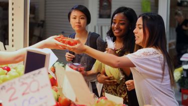Three international students at food market
