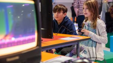 Two children playing games at national video game museum