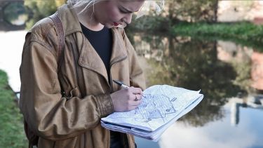 A student marking information on a map - image