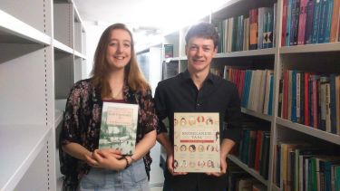 Students with books in library 