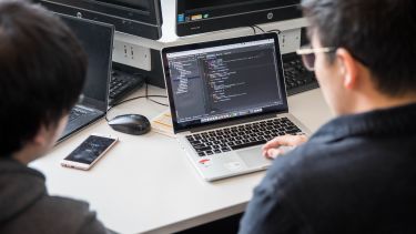 Computer Science students working at a computer