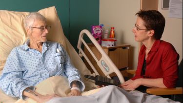 A researcher talking to a patient