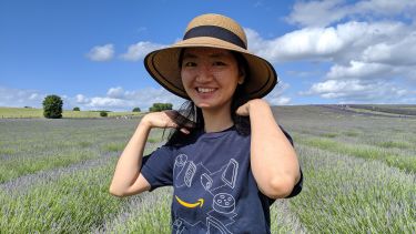 Yulan Liu, PhD Alumni. Standing in a field of lavender 
