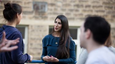 Postgraduate students talking outside Elmfield