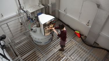 A researcher loads a sample into the 800 MHz spectrometer