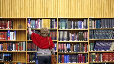 Woman choosing a book from the library