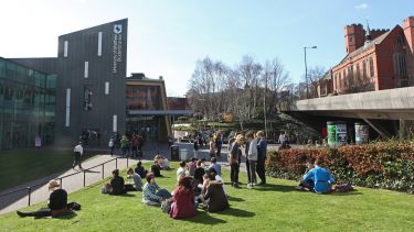 A group of students sat outside of the Students' Union building.