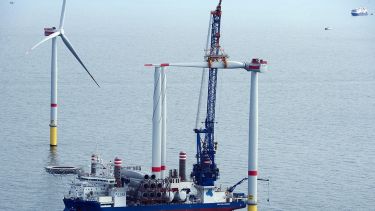 Offshore wind turbine at sea having a blade installed.