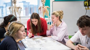 A group of archaeology students review a flipchart in a seminar.