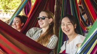 Students laughing in hammocks on a field class