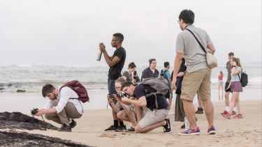 Students take photos on Galapagos beach to investigate coastal processes