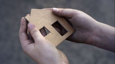 cardboard house in two hands