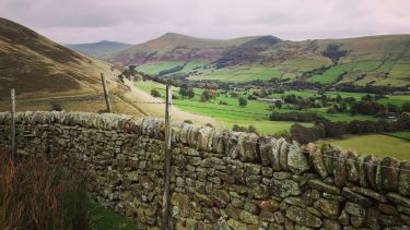 A view of a dry stone wall and valley in the Peak District