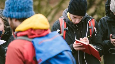 Student writes in notebook during field class