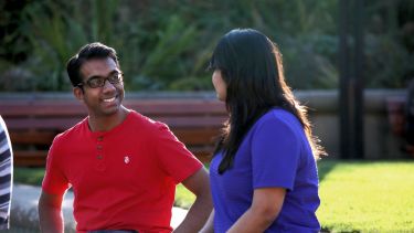 Two students sat outdoors talking.